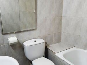 Baño con bañera, inodoro y espejo