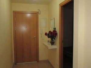 Recibidor con puerta de entrada y estante con flores