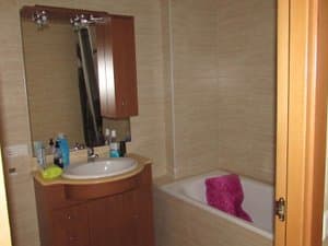 Baño con mueble de lavabo, espejo y bañera