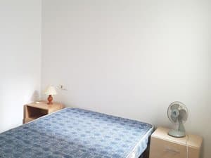 Dormitorio con cama y mesitas