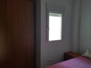 Dormitorio con armario y ventana
