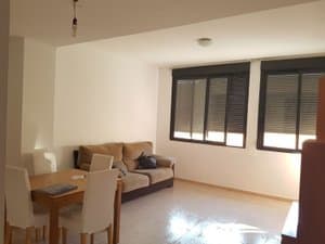 Salón comedor con sofá, mesa y ventanales