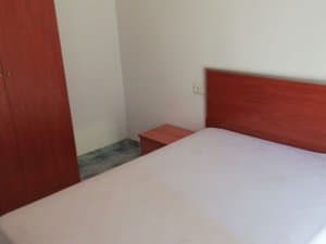 Dormitorio con cama de matrimonio y armario