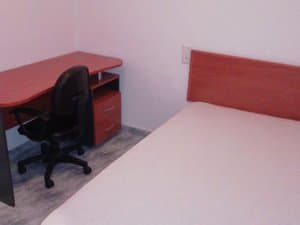 Dormitorio con cama y escritorio