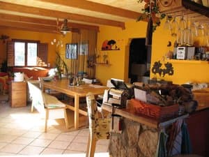 Salón comedor con mesa y vigas de madera