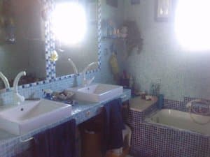 Baño con doble lavabo y bañera de mosaico