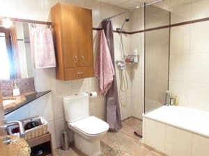 Baño con bañera, mampara e inodoro
