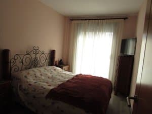 Dormitorio con cama de forja y cortinas