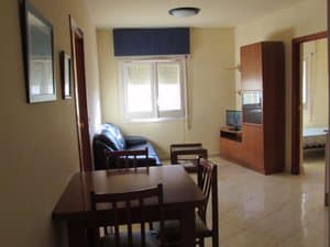 Comedor con mesa, sofá y mueble de televisión