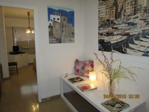 Recibidor con mueble blanco y cuadros