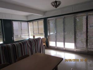 Salón comedor con ventanales y persianas