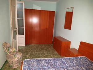Dormitorio con armario empotrado y butaca