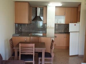 Cocina comedor con mesa, campana y frigorífico