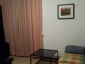 Comedor con sofá, mesa baja y cortinas