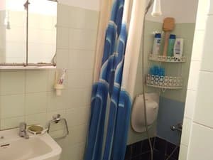 Baño con lavabo, espejo y ducha con cortina