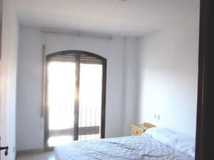 Dormitorio con cama y puerta balconera en arco