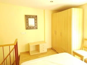 Dormitorio con armario y barandilla de escalera