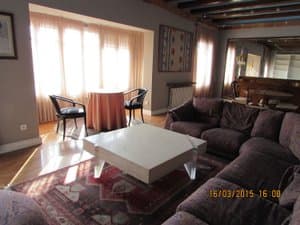 Salón comedor con sofás, vigas de madera y ventanales