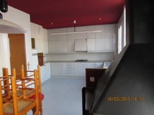 Cocina con muebles blancos y campana