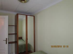 Dormitorio con armario de espejo y estantes