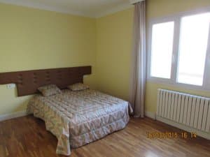Dormitorio con cama de matrimonio y radiador