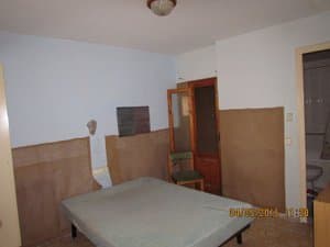 Dormitorio con cama y zócalo de madera