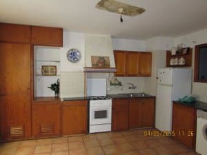 Cocina con muebles de madera, campana y frigorífico