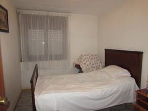 Dormitorio con cama y ventana con cortinas