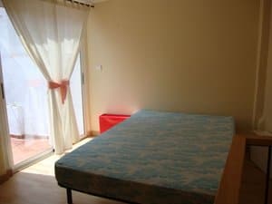 Dormitorio con cama y salida a la terraza