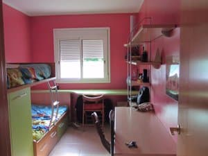 Dormitorio con cama nido, escritorio y estanterías