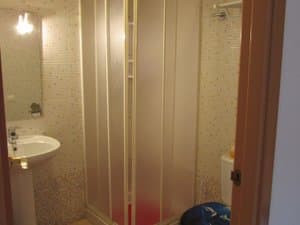 Baño con ducha de mampara y lavabo
