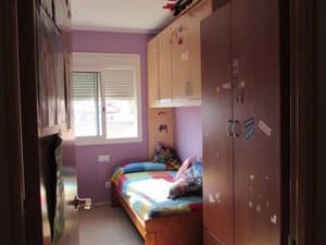 Dormitorio con cama y armario alto