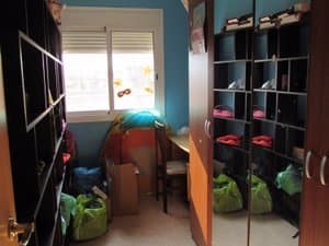 Dormitorio con estanterías y ventana