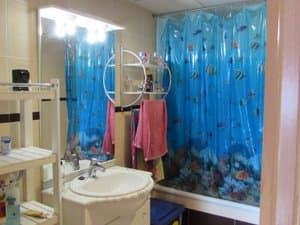 Baño con lavabo sobre mueble y bañera
