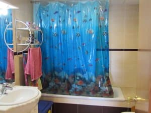 Baño con bañera y cortina estampada