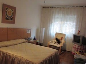Dormitorio con cama y televisor