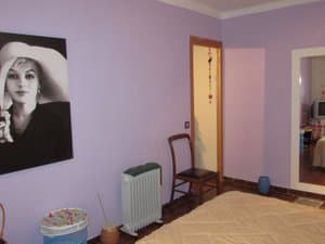 Dormitorio con paredes lilas y radiador