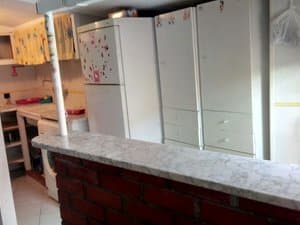 Cocina con barra de obra, frigorífico y lavadora