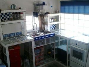 Cocina con paredes de pavés, fregadero y horno