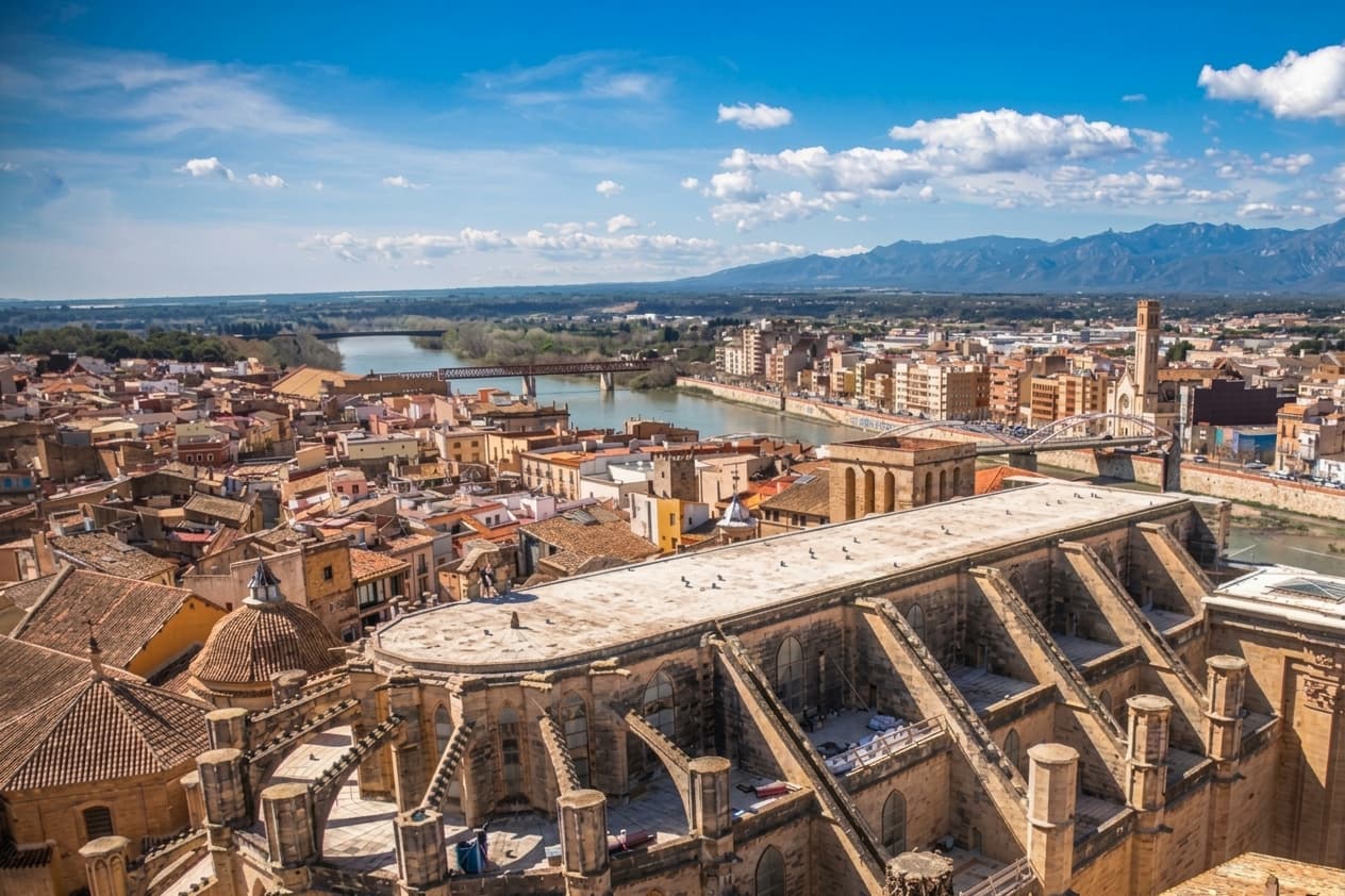 Ilustración de Tortosa vista desde lo alto: la catedral de Santa María, el río Ebro y la sierra de Els Ports al fondo